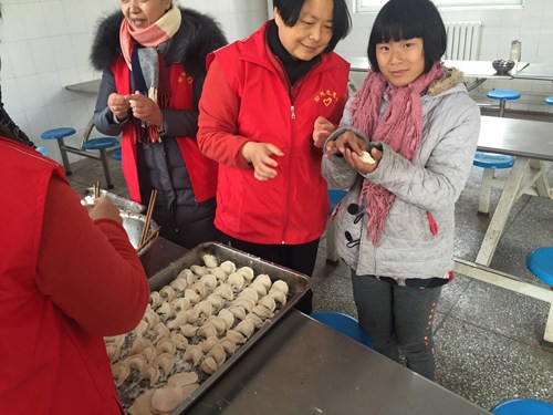 图为：助残志愿者教特教学校孩子包饺子