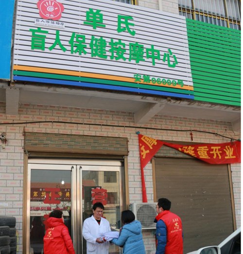 图为内黄县残联志愿者为二安单氏盲人保健按摩中心配发用品