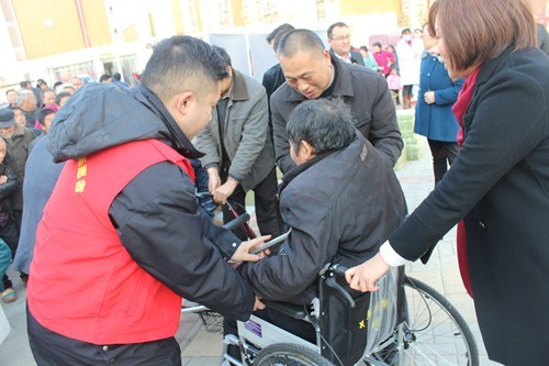 图为为残疾人送去轮椅